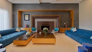 Un salon moderne avec une cheminée, deux canapés, une table basse et un téléviseur.