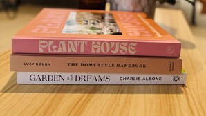 Une pile de livres sur une table en bois dans un salon.
