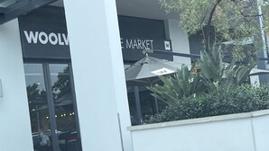 Un magasin Woolworth avec une grande entrée en verre et une enseigne au-dessus de la porte.