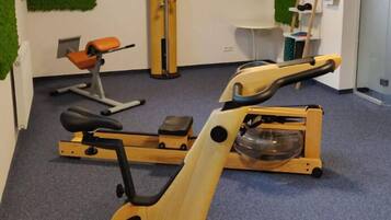 A gym with stationary bikes, a wall clock, and exercise equipment.