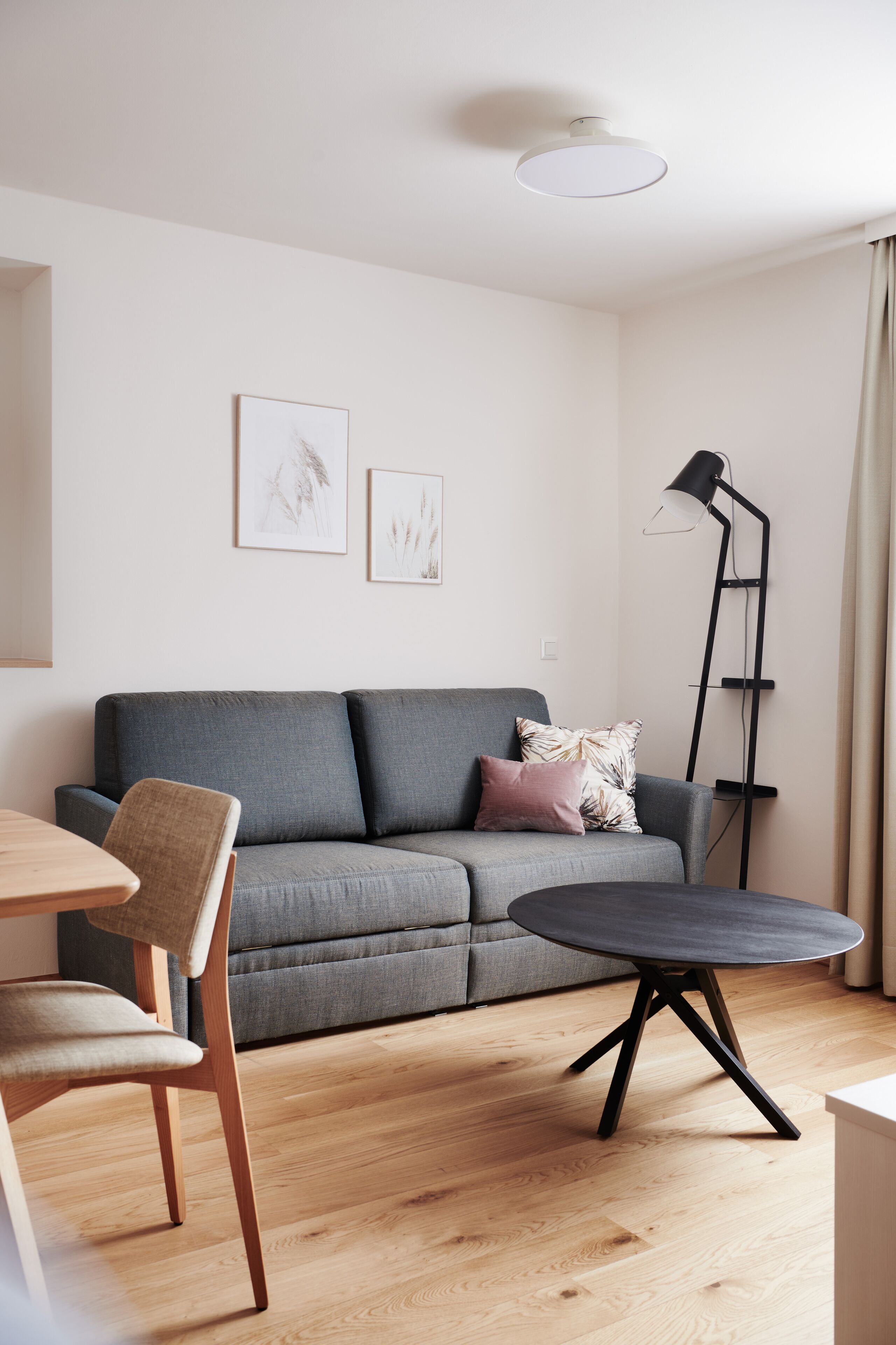 A modern living room with a grey sofa, a round coffee table, and a floor lamp.