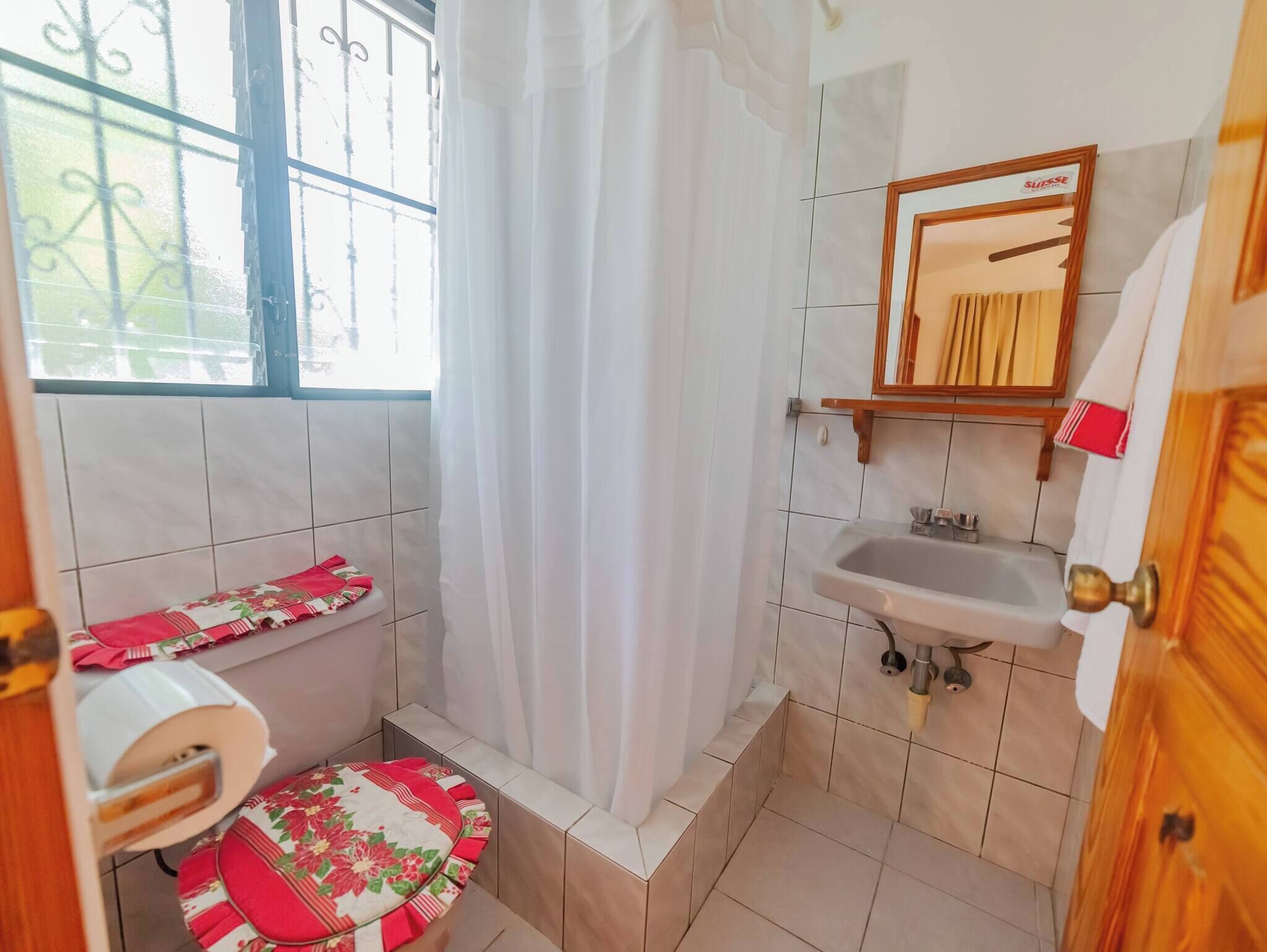 Une petite salle de bain avec des toilettes, un lavabo et un rideau de douche.