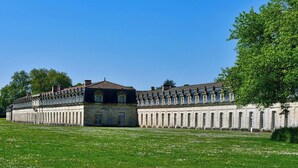 Ein großes, historisches Gebäude mit symmetrischer Fassade, zahlreichen Fenstern und einem zentralen Eingang.