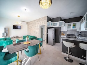 Une cuisine moderne équipée d’un réfrigérateur, d’une cuisinière et de tabourets de bar.