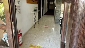 Un pasillo de hotel con un extintor, un cartel de seguridad contra incendios y un letrero que dice 'Lemme By'.