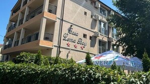 Un edificio de varios pisos con balcones, un letrero que dice "Casa Lema Bay" y una carpa con la marca "SILVER".
