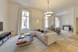 A modern living room with a sectional sofa, a coffee table, and a dining area with a table and chairs.