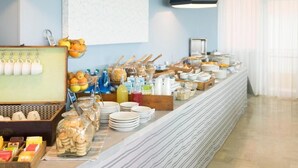 A buffet setup with various food items, utensils, and condiments. - Hotel Salsedine  (Rimini)