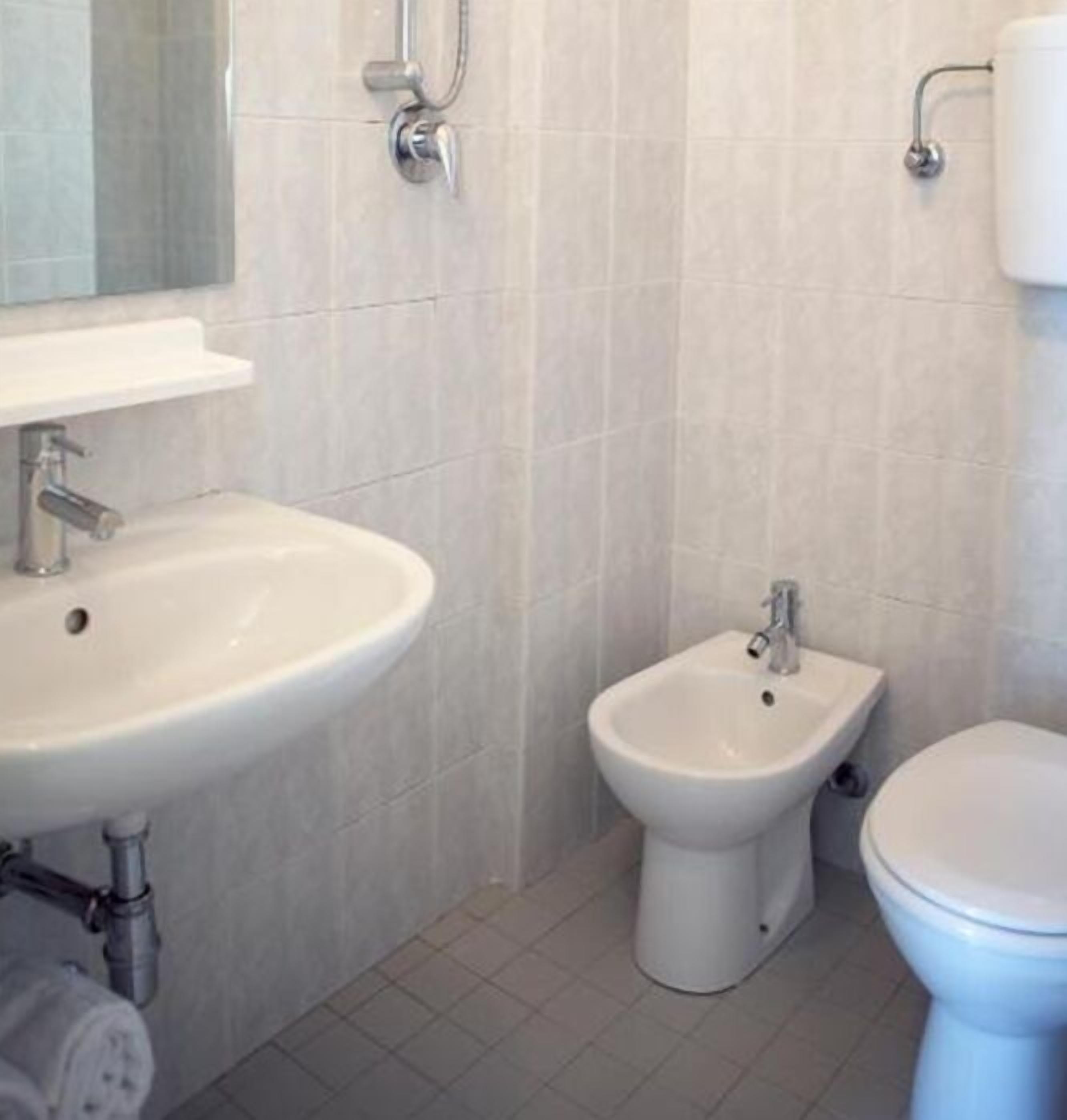 Une salle de bain équipée d’un lavabo, d’un bidet et de toilettes.