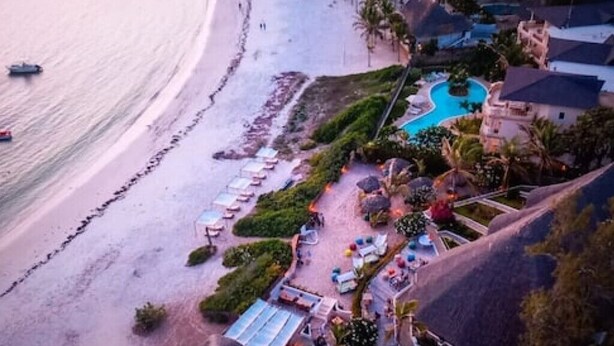 An aerial view of a resort with a beach, a swimming pool, and lounge areas. - Giorgia HouseLuxurious Watamu beachfront apartment (Contea di Kilifi)