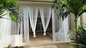 A room with a bed covered in white curtains, a stone floor, and potted plants around the room. - Giorgia HouseLuxurious Watamu beachfront apartment (Contea di Kilifi)