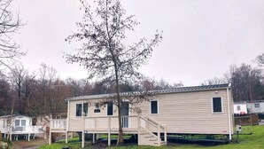 A single-story mobile home with a front porch and a small staircase leading to the entrance.