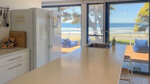 Une cuisine moderne dotée d’une grande fenêtre donnant sur la plage.