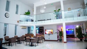 Un vestíbulo amplio con zona de bar, asientos, televisión y un acuario decorativo.