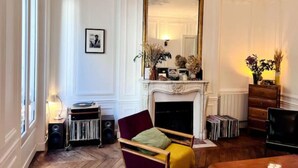 Una habitación con chimenea, espejo, un cuadro enmarcado, tocadiscos y estantería.