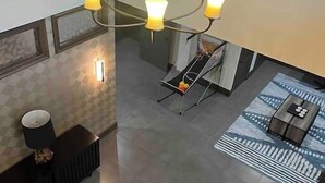 A modern interior with a chandelier, a staircase, and a seating area. - Hill Country Hiatus! (Bee Cave)