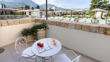 Una terraza con muros de piedra, mobiliario exterior y sombrillas.