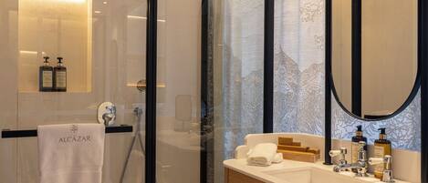 Ein modernes Badezimmer mit einer Duschkabine aus Glas, einem Holzbadezimmer-Möbel und einem großen Spiegel.