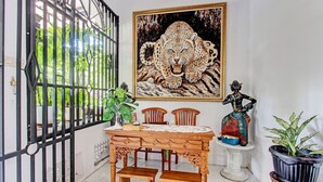Un comedor con una mesa, sillas y una estatua.