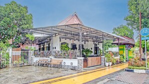 Un espacio al aire libre techado, con bancos y plantas en macetas.