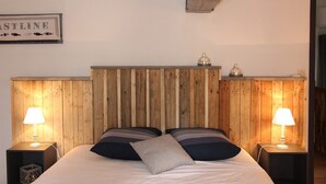 A bedroom with a wooden headboard, two bedside lamps, and a framed sign on the wall.