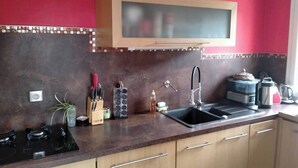 A kitchen with a microwave, sink, stove, and cabinets. - Chambre d'Hôtes l'Hôsting Noix (Hostun)