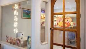 A hotel entrance with a wooden door and a window displaying a sign and decorative elements. - Zhennan Teabar Hotel (Chiang Mai)