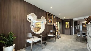 A modern interior with a wooden wall, a round mirror, and a potted plant. - Zhennan Teabar Hotel (Chiang Mai)
