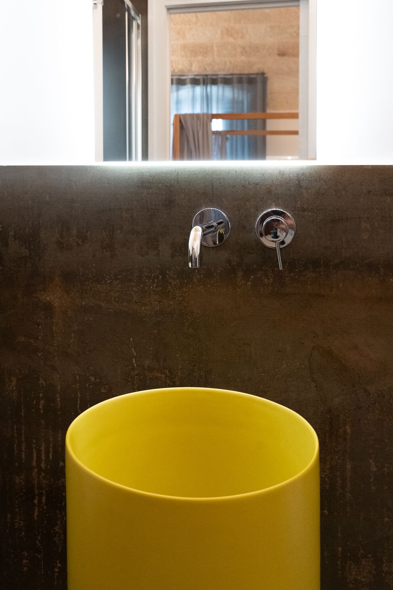 Un baño con un lavabo amarillo y dos llaves.