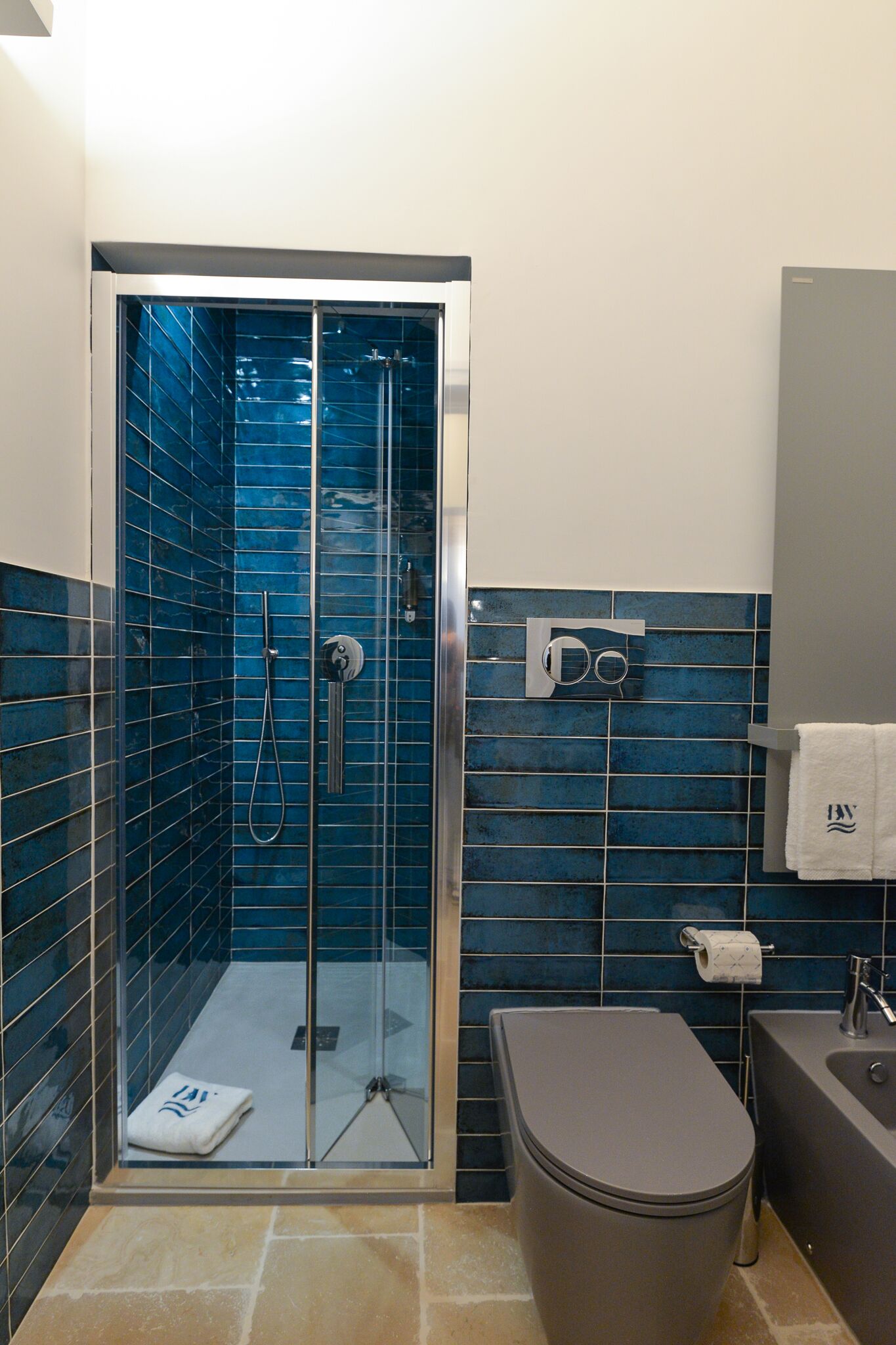Une salle de bain avec une douche à parois de verre, des toilettes et un lavabo.