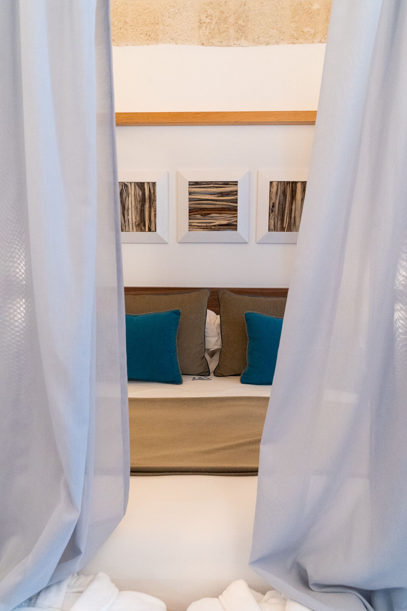 Un dormitorio con cama, almohadas y cuadros en la pared.