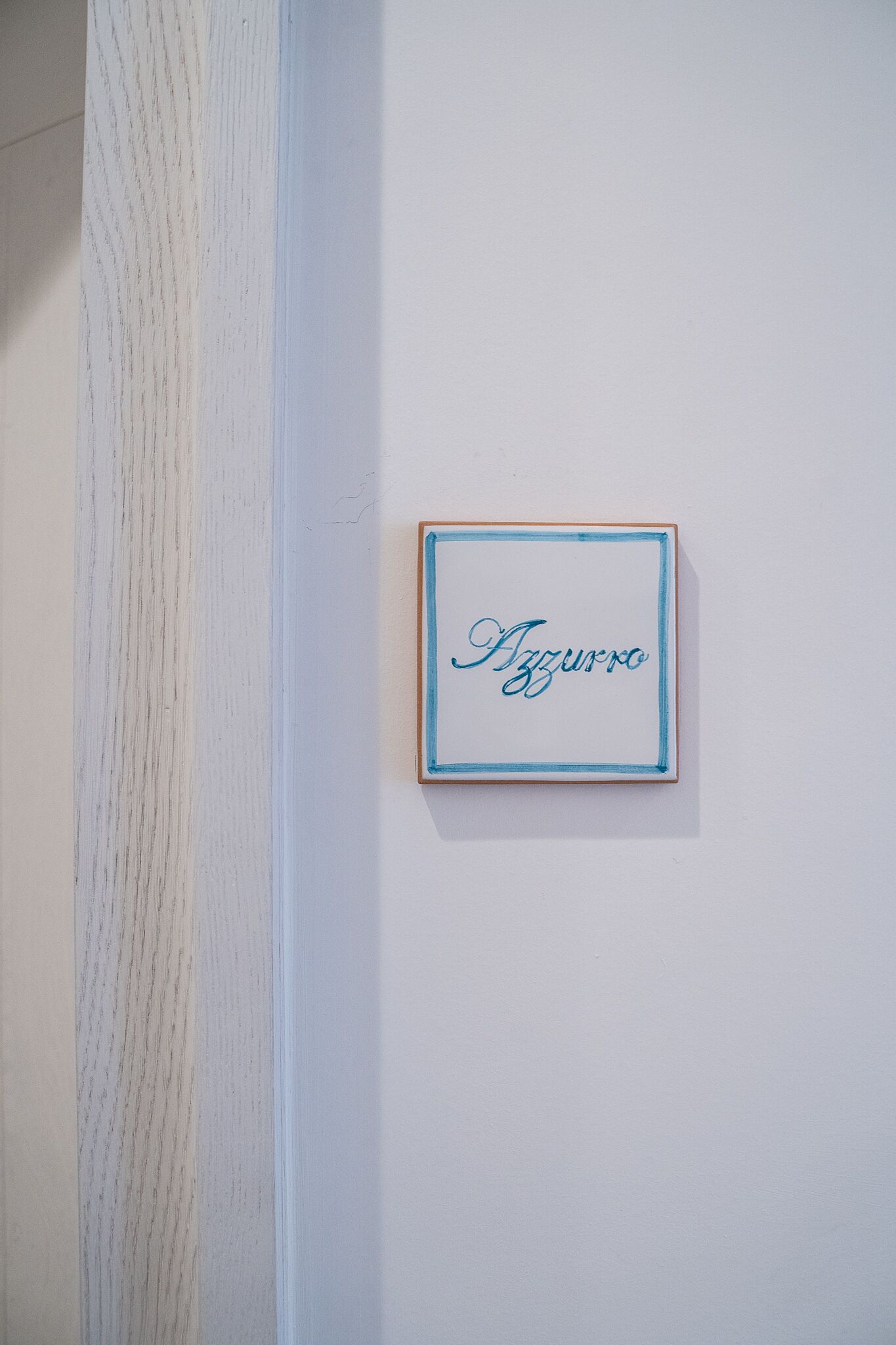 Una placa con marco en una pared blanca que muestra el nombre 'Azurro'.