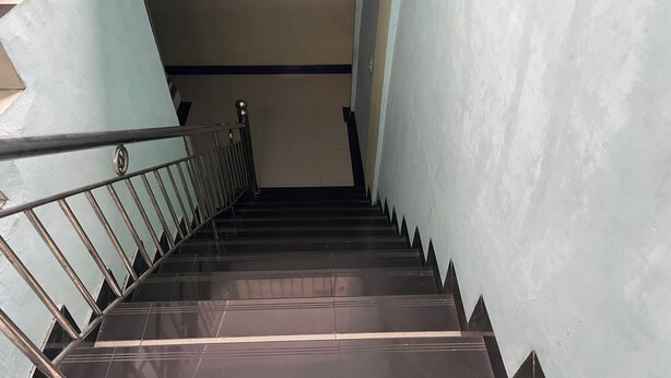 A staircase with metal railings and dark, reflective steps leading to a landing. - Hotel O Syukur 07 Syariah (Medan)