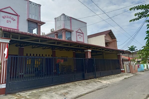 A building with a sign reading "SNOKUR 07" and a gated entrance.