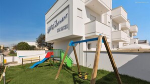 A modern apartment building with a sign reading "ABSOLUTE APARTMENT PORTO CESARE RESIDENCES". - 1049 Absolute - Bilo Piano Terra (Porto Cesareo)