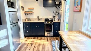 Una cocina moderna con horno empotrado, microondas y refrigerador.