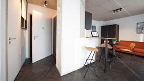 Un interior modern amb zona de menjador, sofà i cuina.