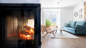 Ein gemütliches Wohnzimmer mit Kamin, einer Couch und einem Couchtisch.