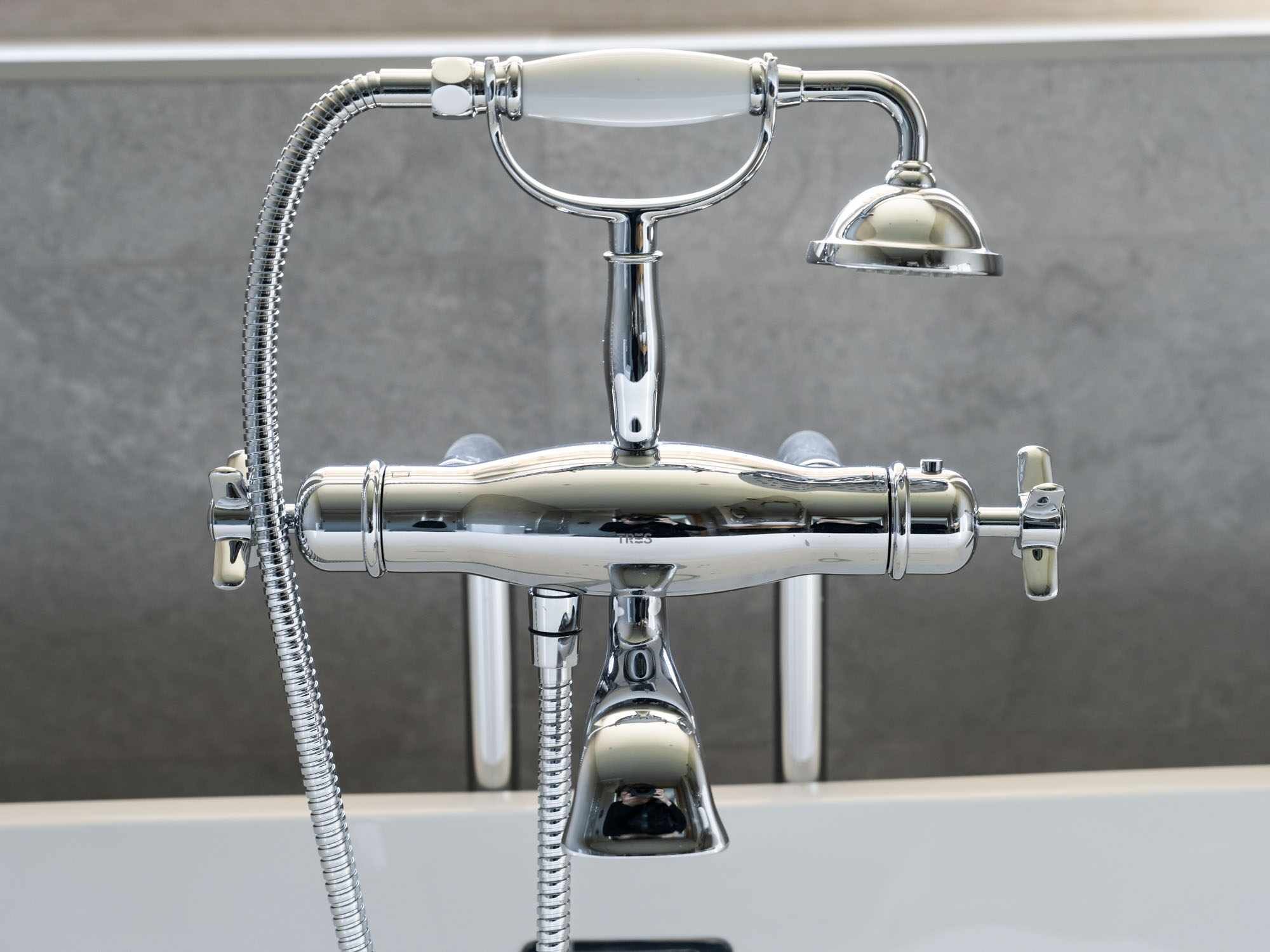 Un accesorio de baño cromado con cabezal de ducha y ducha de mano.