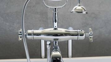 Un accesorio de baño cromado con cabezal de ducha y ducha de mano.