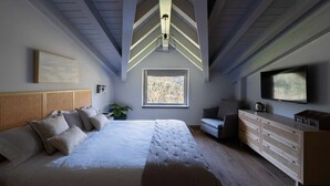 A bedroom with a large bed, a window, a TV, and a wooden dresser. - Enara (Zeanuri)