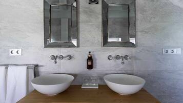 A bathroom with two large white sinks, a wooden countertop, and two wall-mounted mirrors.