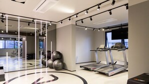 A modern gym with treadmills, exercise balls, and a large mirror.