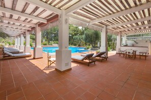 A covered outdoor area with a pool, lounge chairs, and a bar. - 835 Masseria Colosso - Camuffa (Patu)