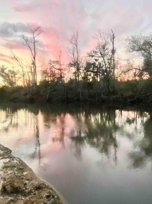 A calm river reflecting trees and a sunset sky. - Luxury Riverside Retreat (Altha)