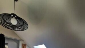 Uma cozinha compacta com armários brancos, micro-ondas embutido e claraboia.