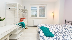 A bedroom with a bed, a desk, a wardrobe, and a window. - Garden Facimiech 6a p4you pl (Kraków)