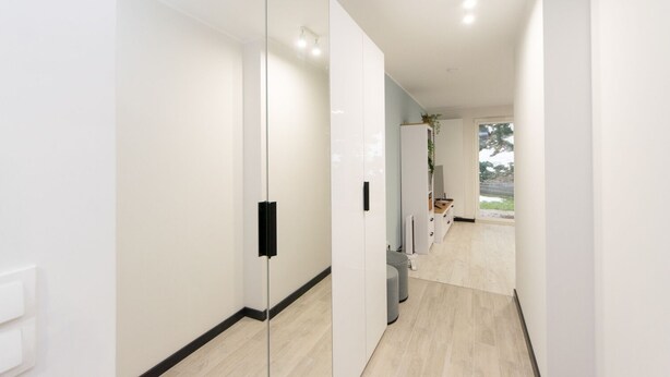 A modern hallway with white walls, a glass partition, and a wooden floor. - Garden Facimiech 6a p4you pl (Kraków)