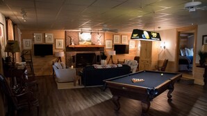 A cozy living room with a pool table, comfortable seating, a fireplace, and framed artwork on the walls. - Family Retreat for vacations, weddings, family reunions and corporate retreats.  (Florence)