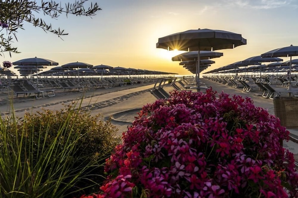 Am Strand, weißer Sandstrand, Liegestühle, Sonnenschirme